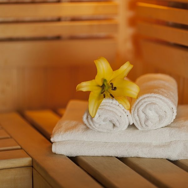 Close up fresh towels and yellow lily in sauna